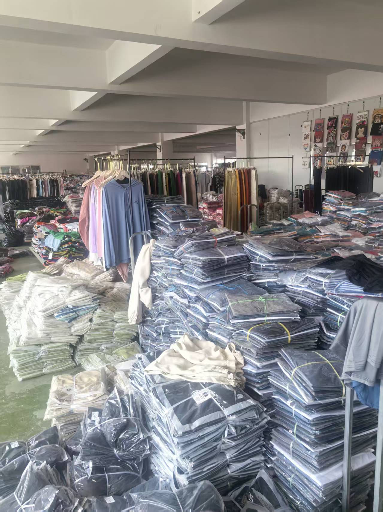 Apparel factory workshop with packed garments, hanging samples, and bulk order inventory